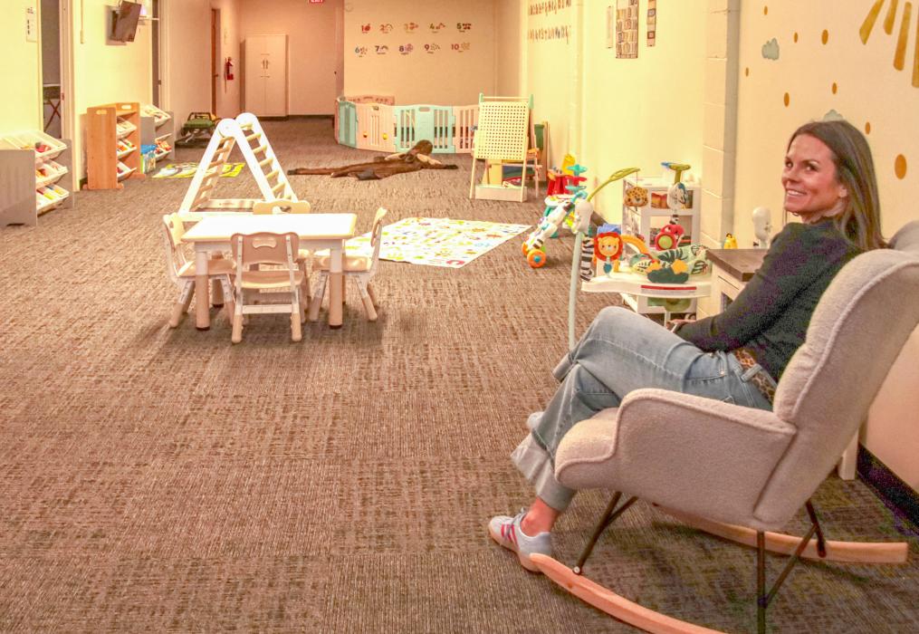 Jill Austin reclines in a rocker in the newly opened Heart City Childcare located in the basement of St. John’s Episcopal Church. Photo by Tina Boone