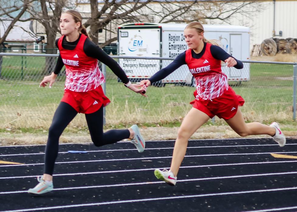 Maeli Patterson and Joni Cox exchange the baton in the 4x100 m relay. The girls team won the relay. Photo by Danielle Arganbright