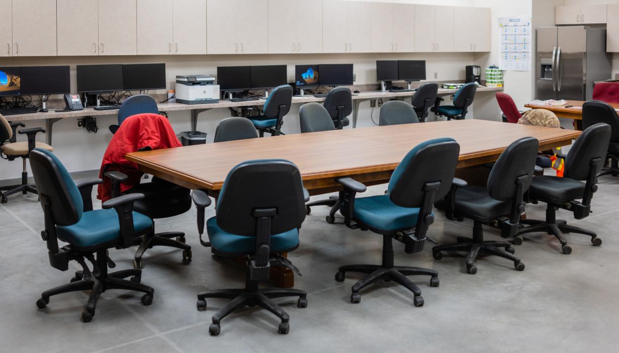 Above, the crew room has several work stations with computers, a large table for meetings, and lockers to stow gear, a refrigerator to stow meals and beverages.