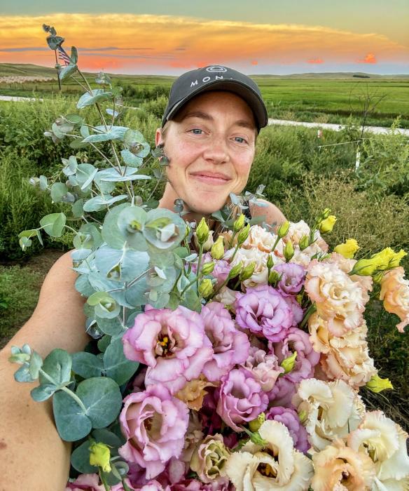 Pictured is Chelsie Moreland of Merriman with a wonderful armful of lisianthus. After health issues, and a word from God, she established Green Valley Flower Farm and sells subscriptions to various flowers and herbs throughout the growing season.