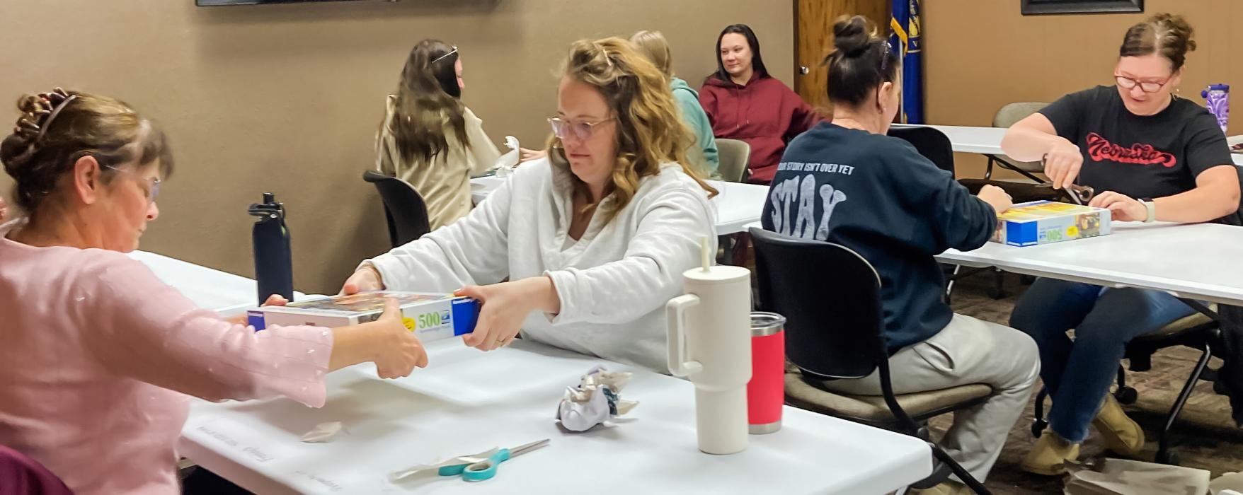 Participants of the Friends of the Valentine Public Library Puzzle Tournament begin the unboxing process Saturday morning. This group was putting together the 500 piece puzzle.