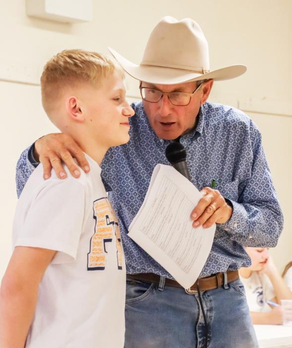 The annual FFA Hired Hand Auction raised more than $30,000 for the students to go to state. Pictured above, auctioneer Greg Arendt confers with a student who is up on the auction block. Photo by Tina Boone