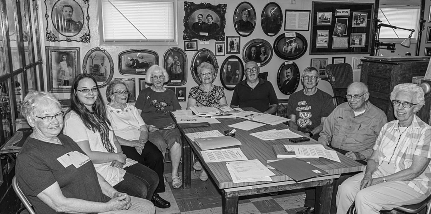 A new generation watches over the memories of a former generation adorning the walls at the Cherry County Historical Society Museum. They recently elected new officers. Pictured are from L to R: Board Member Carolyn Wickett, Board Member Jodi Birch, Treasurer Viola Coleman, Curator Margaret Lutter, President Joyce Muirhead, Vice President Jim Edwards, Board Member Gregg Gass, retiring Board Member Martin Nollett, and Board Member Jean Schemm. Photo by Laura Vroman