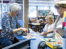 Janelle Schubauer checks out local patrons at the Valentine Public Library. Photo by Tina Boone