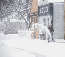 John Miller of True Value is out clearing off his south sidewalk during the April 1, 2024 snow. Photos by Laura Vroman