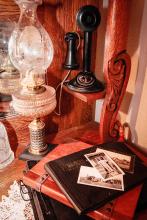 A quiet shelf of the past: an old lamp, telephone, and time worn photographs, remind us that traditions live in the everyday objects we choose to preserve, carrying stories forward long after the voices have faded. Photo by Tina Boone