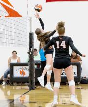 Lilly Ravenscroft tips the ball back across the net against the Rams, while her sister #14 Kayleigh covers. Photo by Shontell Rosberry