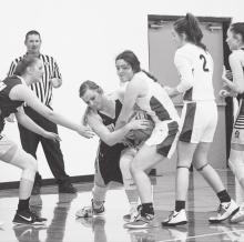 Grappling for the ball, the Cowgirls and Lady Warriors played December 4.