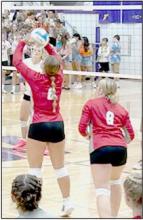 Kimber McGinley prepares to bump set a tight pass to middle hitter Aubrey Benson. Savannah Fullerton ready to move in for coverage.