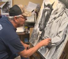 David Dorsey at his easel, working on a portrait.