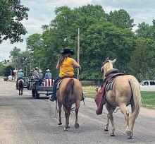 Willard Hollopeter’s flag-draped casket was transported on an old western wagon from his former home in Wood Lake to his final resting place at Mount Hope Cemetery in Wood Lake. The caisson was pulled by two horses; the riderless horse was led by rider Julie Hollopeter Owens. Amidst flags flying at the cemetery, American Legion Post 123 was in charge of Military Honors. Photo by E. Fowler