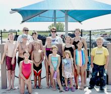 Some of the GNST Swim Team is pictured: back row, L to R: Coach Susan Tiefenthaler, Coach Shevaun Adams, and Aubrey Benson. Middle row, L to R: Ryan Adams, Henry Johnson, Reed Greenough, Sarah Burge, and Emily Benson. Front row, L to R: Brooke Nelson, River Ruby, Nova Ruby, Maddie Johnson, Adalyne Valen, and Sam Johnson. Other swimmers not pictured include: Anniyah Bailey, Tryston Bailey, Lilyan Kornely, Aiden Buckendahl, Jenalee Garwood, Sharon Araujo, Corbyn Huddle, and Eil Huddle.