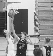 Cameron Jordan #11 goes for an under the basket shot against Ogallala. Photo by Mary Reagle