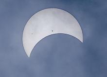 Cloudy skies made photographing the eclipse challenging, but viewing among the swirling clouds was riveting! Notice the sun spots visible - reserved for cloudy, or smoky skies, but always there. Photo by Laura Vroman