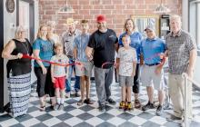 Pictured at Third Street Barber Shop’s Ribbon Cutting are from L to R: Nadeane Allard, Deanne Holmes Monroe, Jack Monore, Kim Burge, Gene Eddie, Owen Moosman, Adam Moosman, Evan Moosman, Beckey Moosman, Jason Kelber, and Dean Jacobs. Photo by Laura Vroman