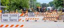 Nine inch doweled concrete roadway is being placed, driveways, and sidewalks are being built. Finish grading is under way.