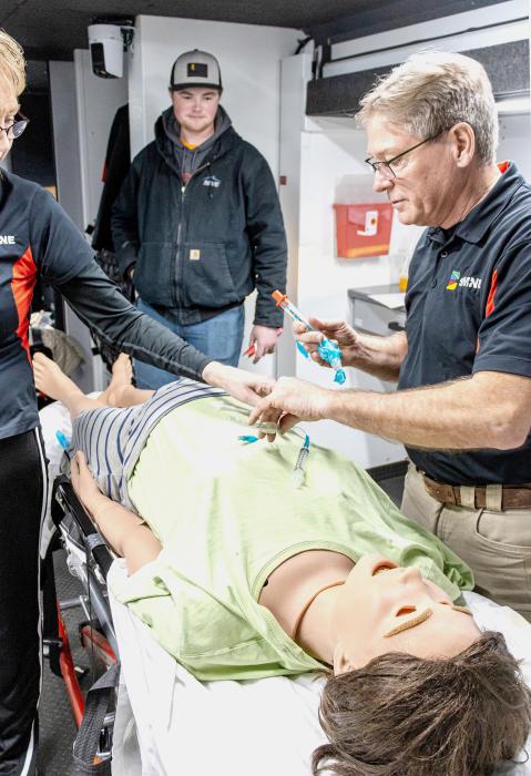 The mannequin, Lucina, is being prepped for an intubation by trainers James Staab on the right, and Kenda Kuehner, far left, along with a new EMS volunteer, center.