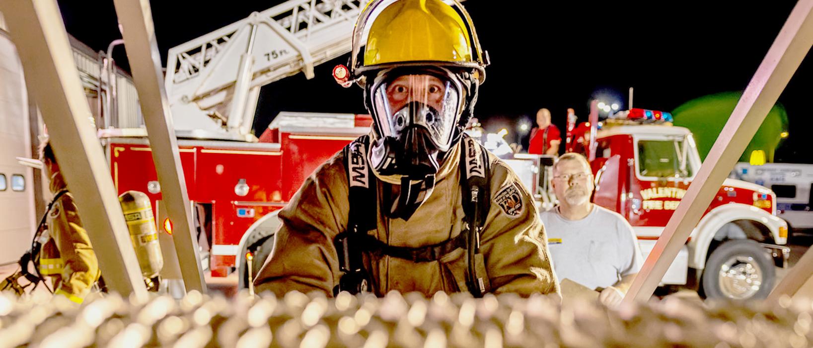 Headed up the stairs on the training trailer, this firefighter will learn how best to deal with fires from the angled pitch of a roof, while flames, heat, and smoke attack. Strategies on how to attack back were learned and refreshed Tuesday, October 17, 2023. Chief Terry Engles stands to the right overseeing the event. Photos by Laura Vroman