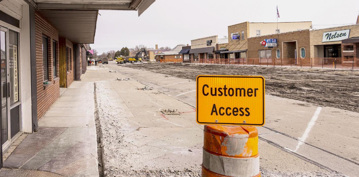 A sidewalk cut on the west side of Main Street in front of the old theatre and Reese Propane will be removed. The sign shows that Main Street businesses are OPEN!