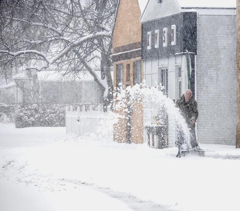John Miller of True Value is out clearing off his south sidewalk during the April 1, 2024 snow. Photos by Laura Vroman