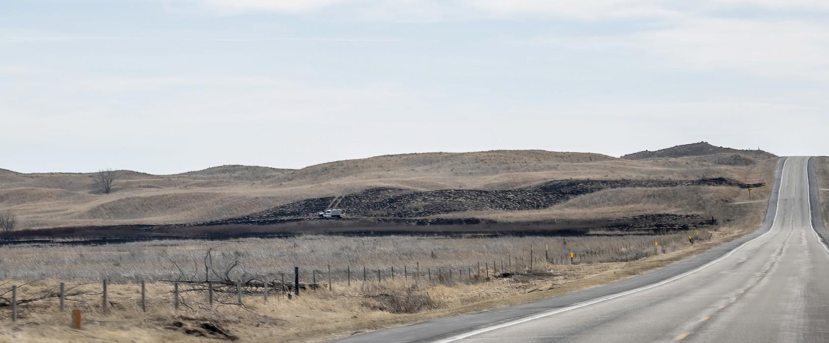 Headed south on Highway 83, the burn marks near the shoulder of the road tell a story! Attacked by several departments along with the SEAT plane from Broken Bow, the fire was limited to 283 acres at Valentine National Wildlife Refuge. A grass rig sits in a basin, ever watchful for flare-ups. Photo by Laura Vroman