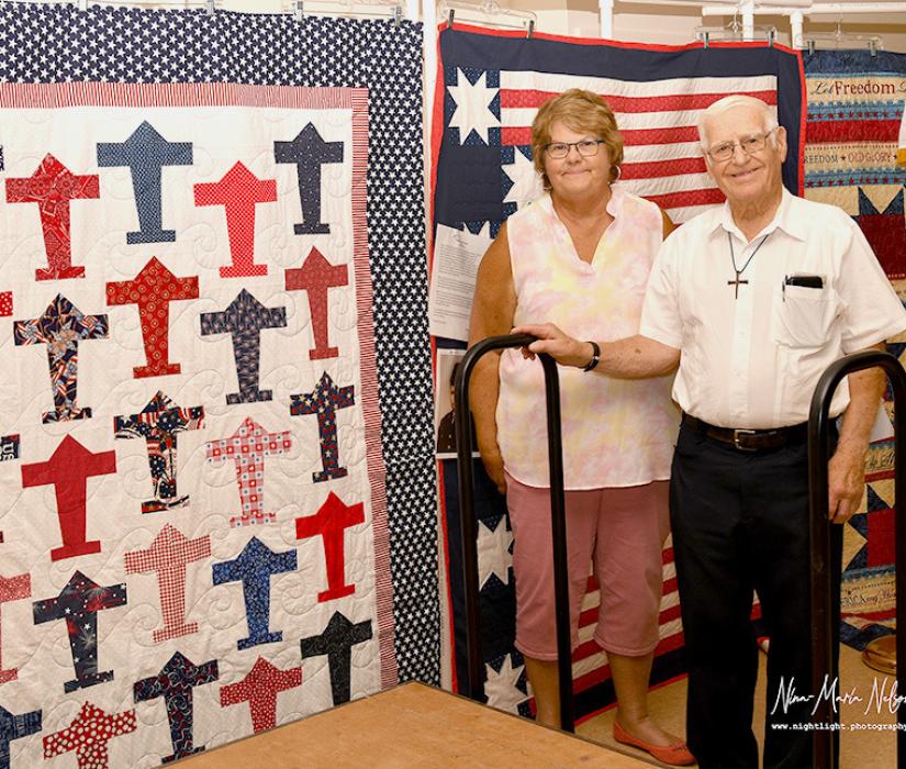 Rhonda Cherry presents Bob Kilmer with his Quilt of Valor.