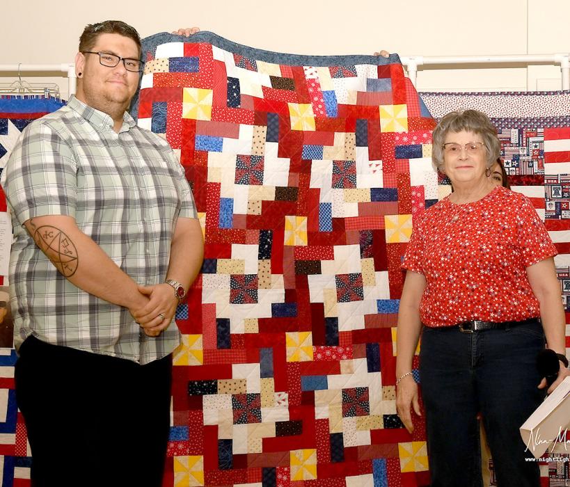 Judy Roosa presents Heath Bristol with his Quilt of Valor.