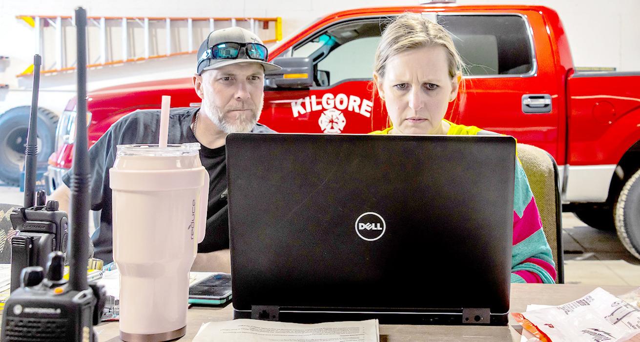 Justin Nickless and Jessica Coyle try to estimate the number of acres that were burning while filling out online information for help.