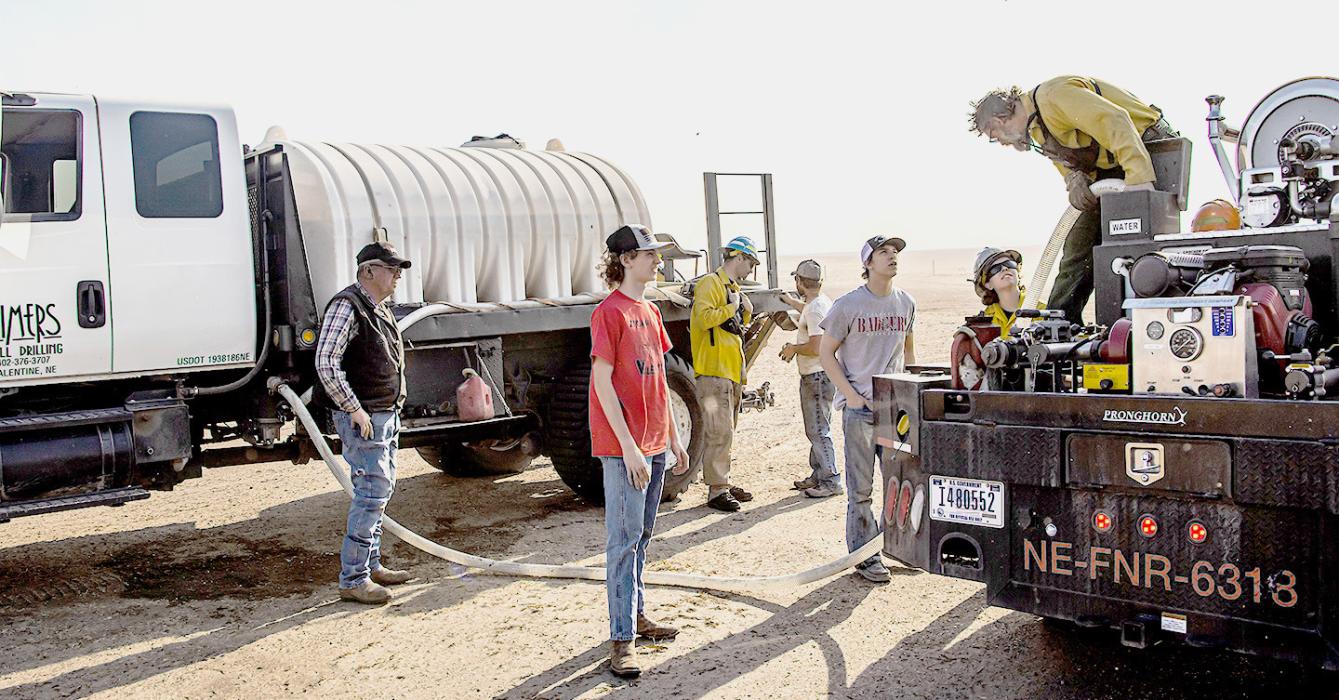 A record setting temperature of 92 degrees was reached Tuesday, April 11, 2023, which didn’t help with firefighting efforts. Pictured are Ethan Cozad and Johnny Kruger who traveled to the grain bins, south of Kilgore, offering Subway sandwiches to hungry and tired fire fighters.