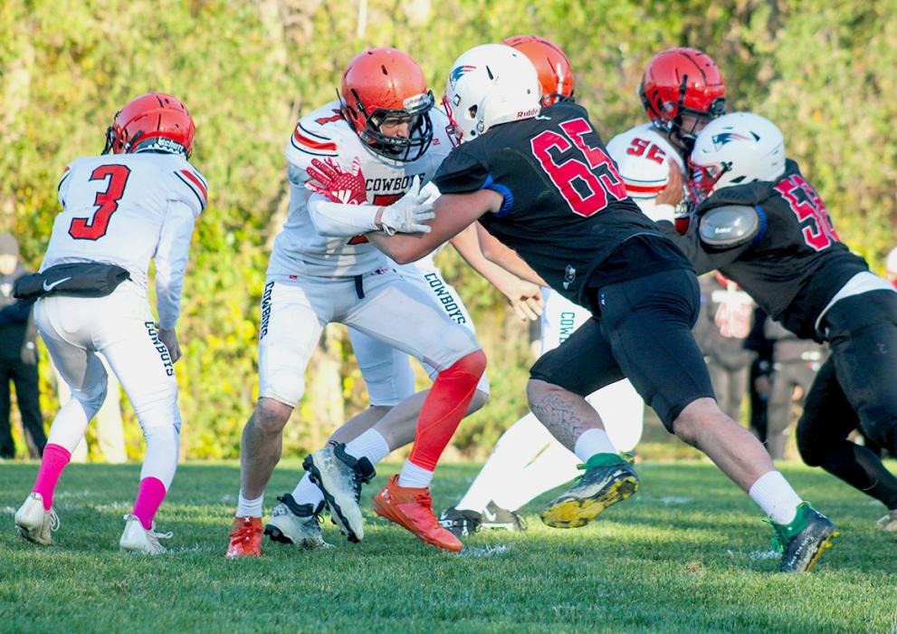 Tristan Fish #3 hands the ball off while Drew Farrell #7 and Trey Hand #52 work on the line.