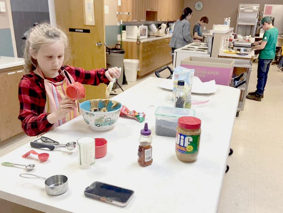 Tyson Cochran (L) and Jaydn Danielski (R) in background are working on their cupcakes.