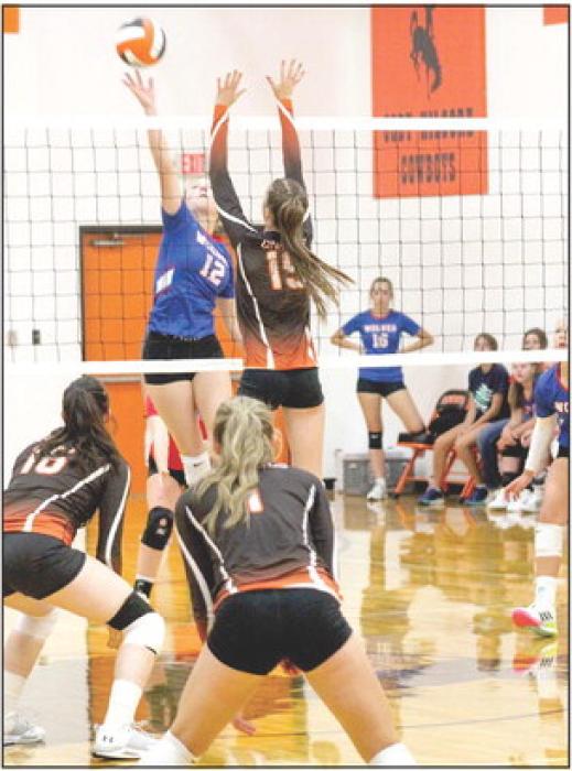 Kate Cox #19 goes up to block while teammates Mikah Vander Wey and Ally Heath cover during the game against Arthur.