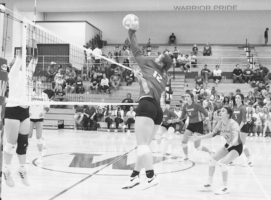 The Warriors go up to protect the oncoming ball by #12 Ava Reagle.