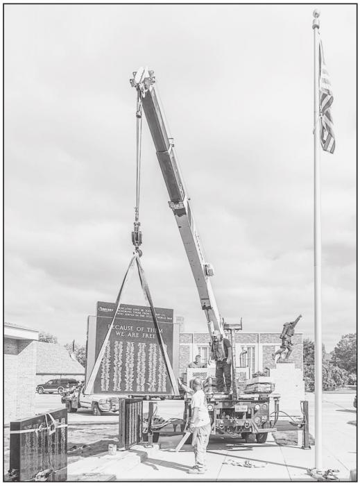 Gregg Perrett, Kerry Hoffman, and Shaun Kiser work together to remove the WWII monument, along with the other monuments which will be stored until a later date. Kerry said the removal went perfectly.