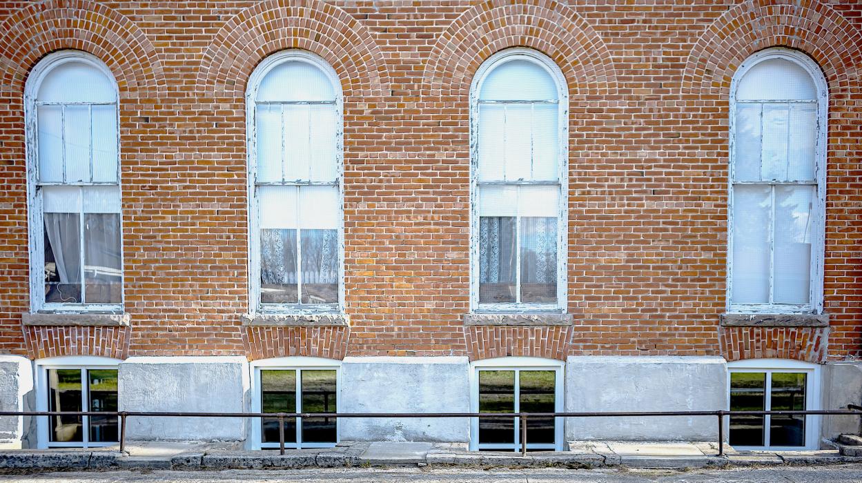 Centennial Hall has new windows at the basement level, which were recently installed and are made of aluminum, compared to the upper windows, made of wood, which are affected by the varying weather conditions and are more than 100 years old. Photo by Laura Vroman