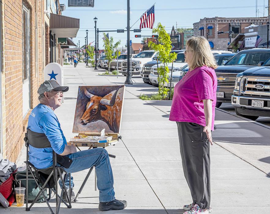 Artist David Dorsey paints outside Janine’s Flower Exchange. Notice how full parking is for this event!