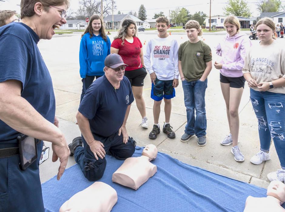 EMS personnel Christine Lousias and Duane Lamb show the students how to do chest compressions using their training dummies - who were actually pretty smart and lit up when the compressions were done correctly.