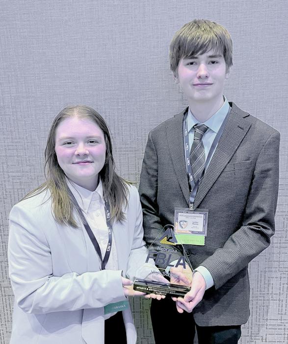 Emma Kreutner and Landen Mooney with their first place trophy in Sports and Entertainment Management trophy.