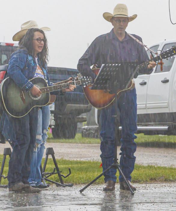 Kitty and Rick VanderWey sang God Bless the U.S.A. in the falling rain. Photos by Laura Vroman