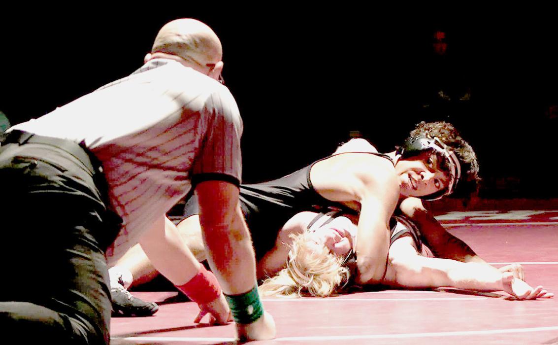 Nick Ohlmann looks to the ref for the pin in the triangular at Ogallala. Ohlmann wrestled in the 145# weight class.