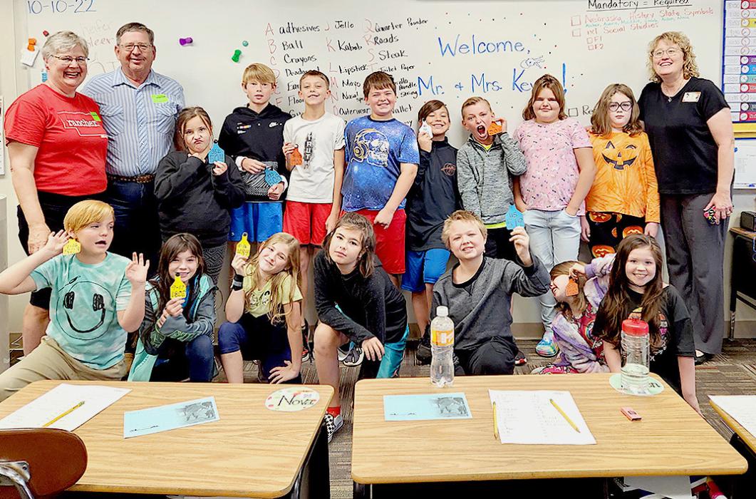 AITC rancher penpals, Kerry and Anita Keys, visit their 4th grade class in Ogallala showing off their calf tags.