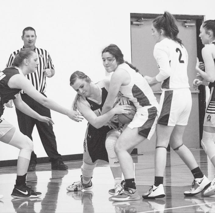 Grappling for the ball, the Cowgirls and Lady Warriors played December 4.