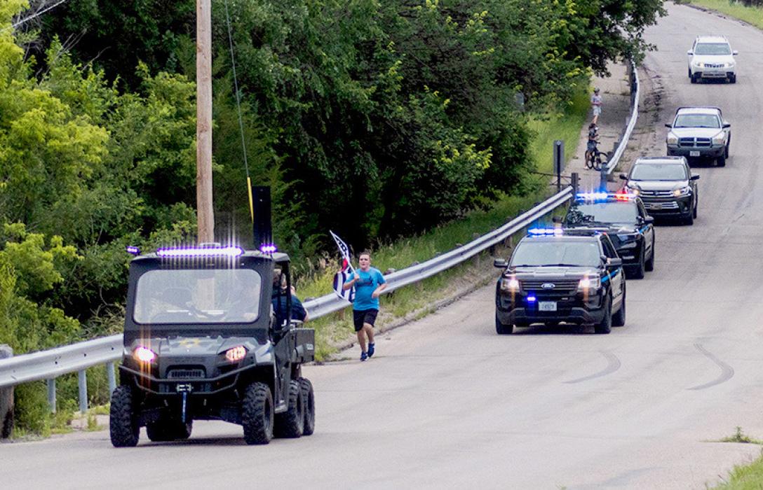 Pictured above left is Officer Jasmine Hoefs Law Enforcement Purple Heart. Above, Zechariah Cartledge is running the Park Route in honor of Hoefs, and is followed by Valentine Police Department.