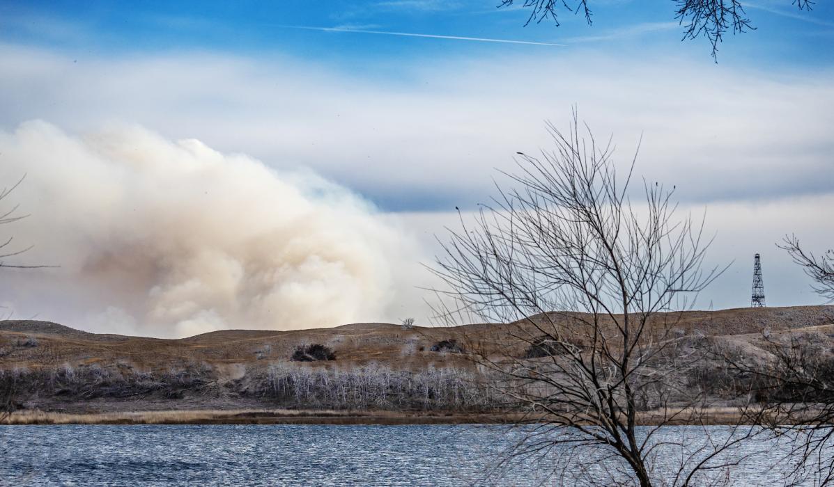 Overlooking Hackberry Lake on Nebraska 16B Spur, a giant cloud of smoke is being windswept , and rolling over the barren hills. Notice the CCC Fire Tower on the far right for a size perspective. Photos by Laura Vroman