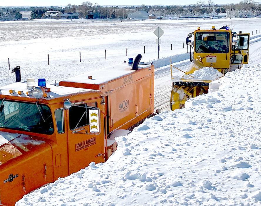 Above, snow blowers clear off the road south of Nenzel. At right, snow sculptures reach the roofline in Crookston. At far right, blowers take care of a drift that dwarfed them on Highway 16 F south of Nenzel. Photos courtesy of Dennis Connot and Michelle Garwood