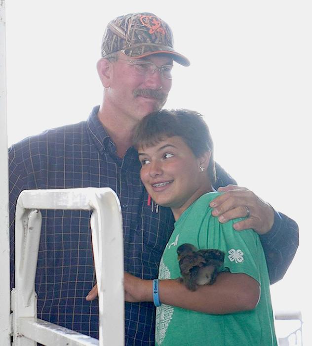 Addie Sexson hugs her father, Ryan Sexson. Addie and Rylie, his daughters, nominated Ryan for the Individual Friend of 4-H for 2023.