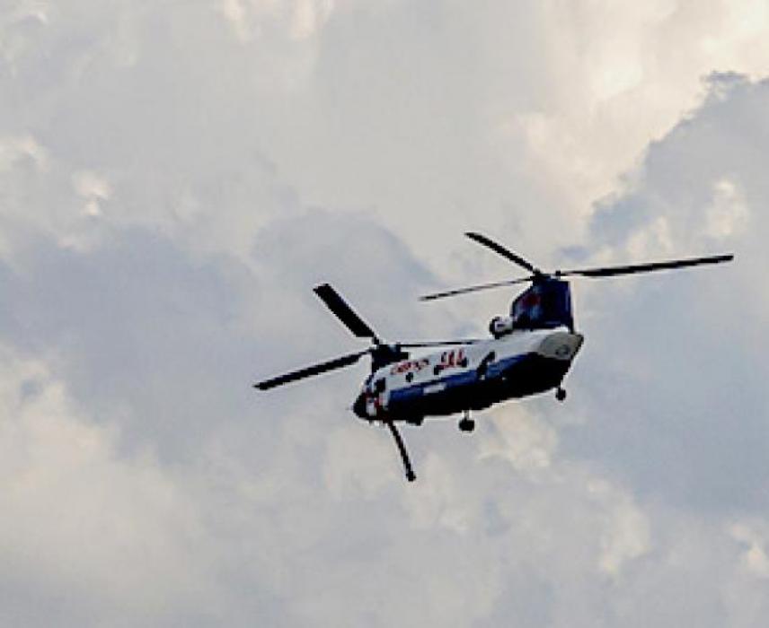 At right, after filling with water through its syphon hose, this helicopter from Billings, headed into thunderheads to help with the fire in St. Francis, SD.