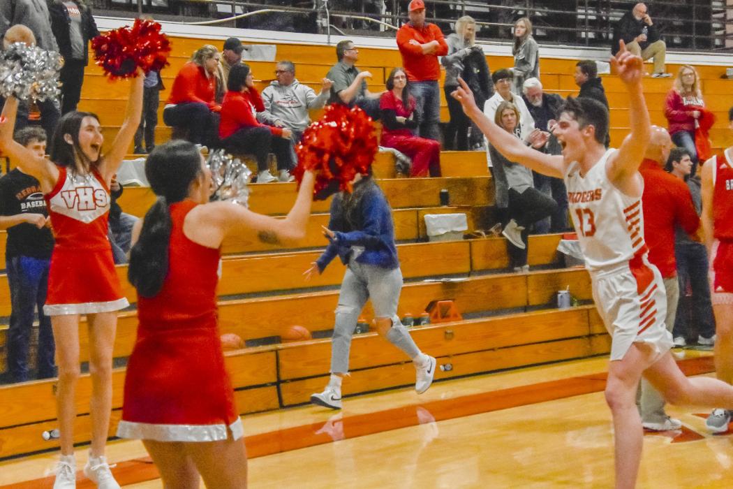 The VHS Cheerleaders rejoice with Badger Jack Lancaster #13 after their win over Broken Bow in the Southwest Conference Tournament. Photo by Kris Larsen