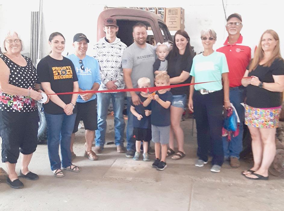 Photo by Dean Jacobs Pictured at the Wrenched Tire and Auto, LLC Ribbon Cutting are from L to R: Nadeane Allard, Ann Krueger, Jason Kelber, Brayden Battershaw, owners Ryan Battershaw and Shyloe holding Pehren Batterhsaw, Kim Burge, Mike Burge, and Deanna Holmes Monroe. Front row, L to R: Rehesten Battershaw and Hutchen Battershaw cutting the ribbon.