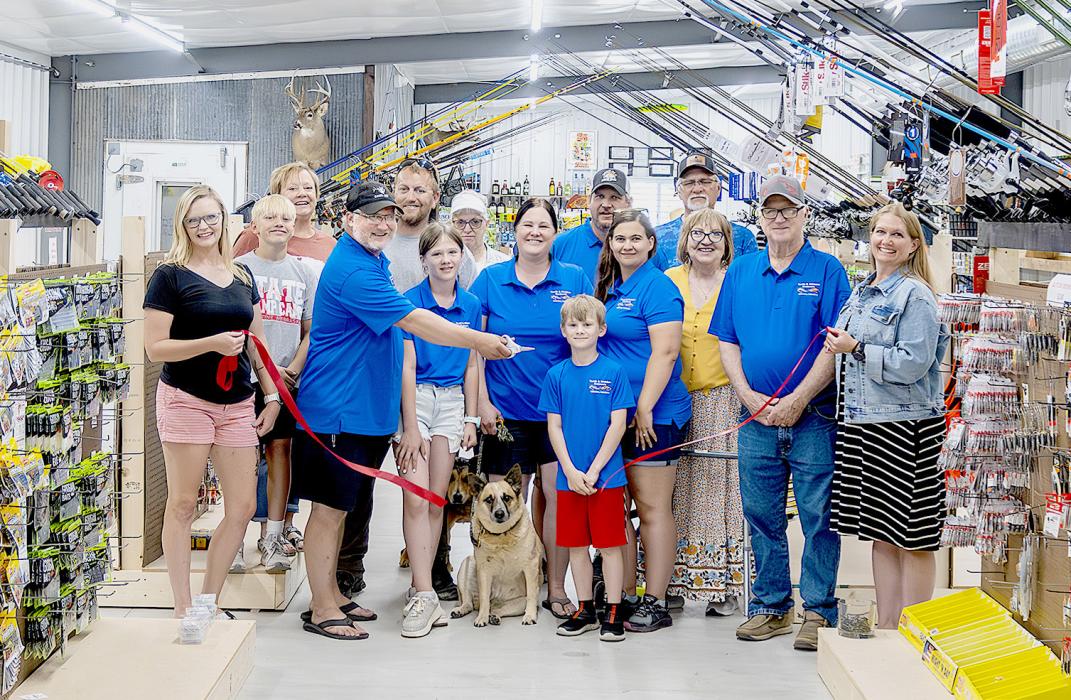 Pictured at the Tooth and Whisker Outdoors Ribbon Cutting are back row, L to R: Susan Stec, Jeremy Stec, Diana Ostrander, Josh Purdy, and Mike Burge. Front row, L to R: Jennifer Moore, Brayden Stec, Tyler Brown, Elise Brown, Andrea Brown, Weston Brown, Dawn Shelbourn, Angie Brown, Greg Brown, and Deanne Holmes Monroe. Photo by Laura Vroman